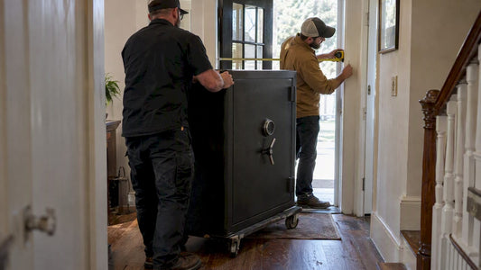 Movers measuring a doorway beside a safe