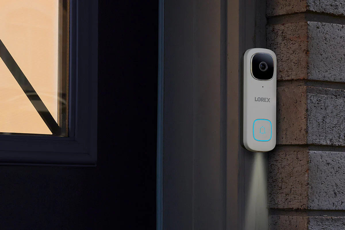 Lorex doorbell camera mounted on a brick wall next to a window.