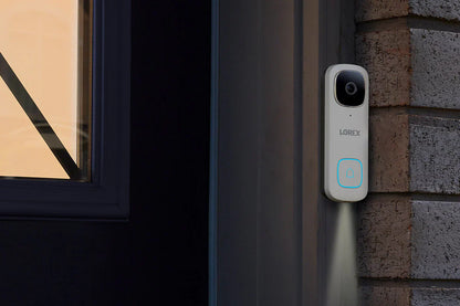 Lorex doorbell camera mounted on a brick wall next to a window.